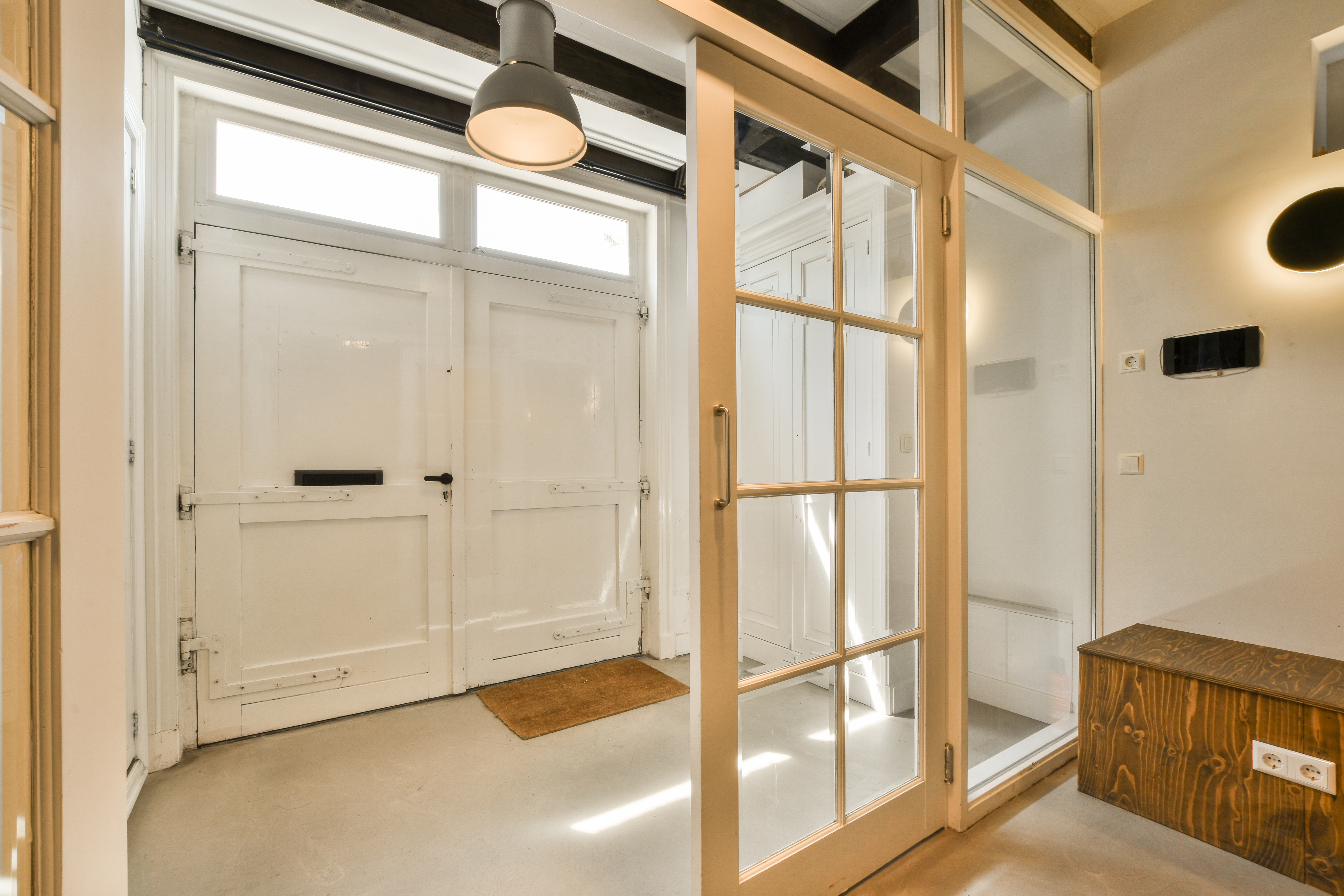 Exposed original beams and a crittall-style glass door during a London renovation